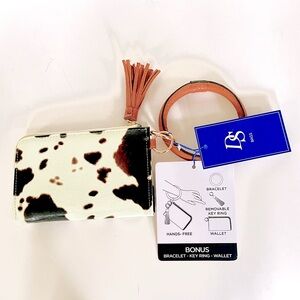 Cow pattern wristlet with keychain. Faux leather is cream with dark brown spots.